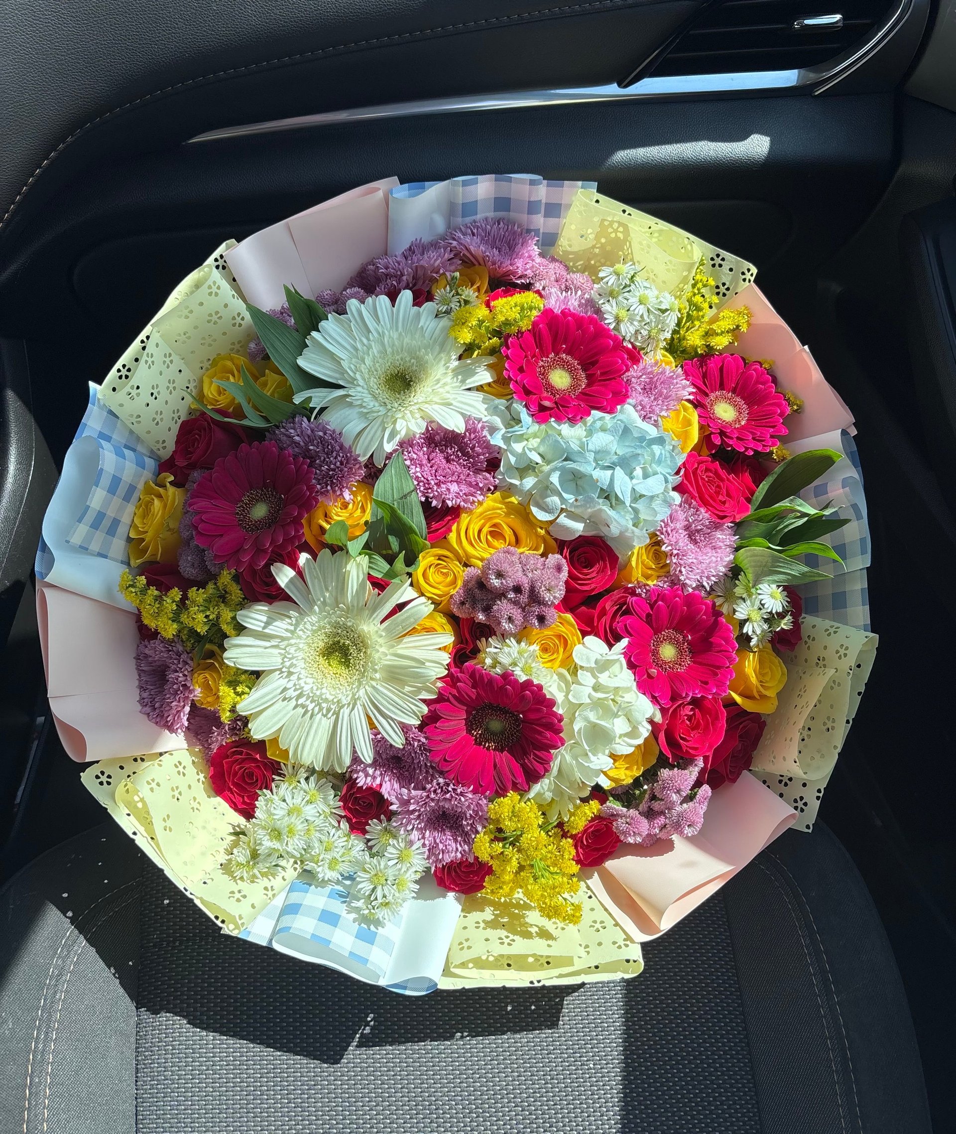 Colorful bouquet of mixed flowers including gerberas, roses, and daisies